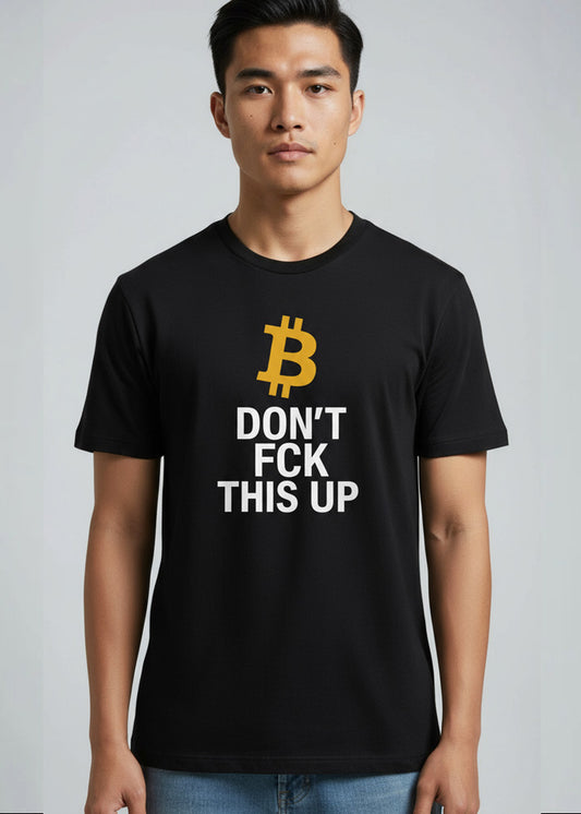 Person wearing a black organic cotton t-shirt with a gold Bitcoin symbol and the text “Don’t FCK This Up” on a neutral background.